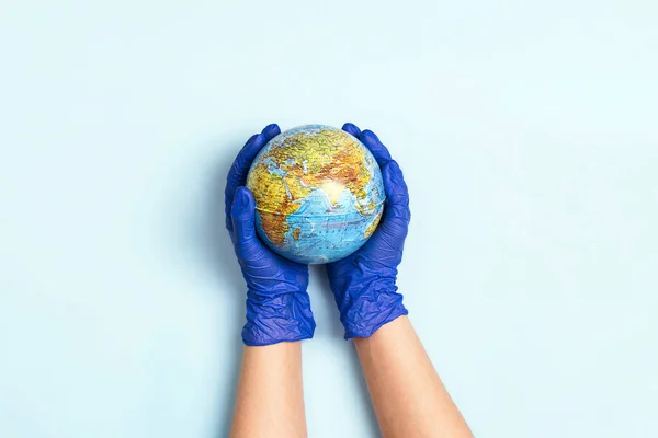 Ręce Rękawiczkach Medycznych Trzymających Kulę Niebieskim Tle Globalna Pandemia — Zdjęcie stockowe