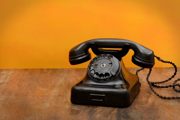 Retro zwart telefoon op houten tafel achtergrond met kleurovergang — Stockfoto