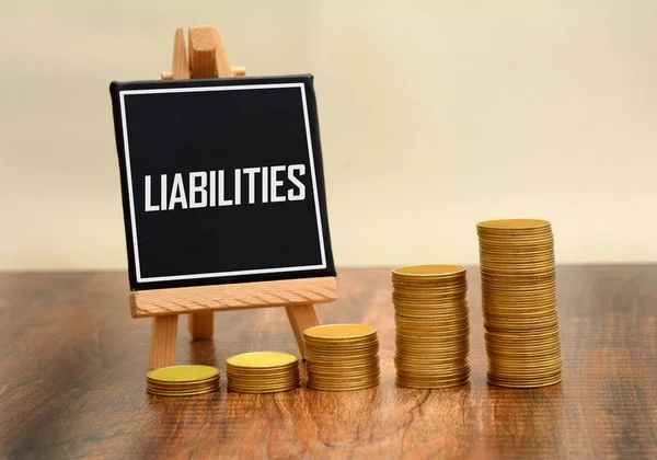 Liabilities black board with golden coins stack — Stock Photo, Image