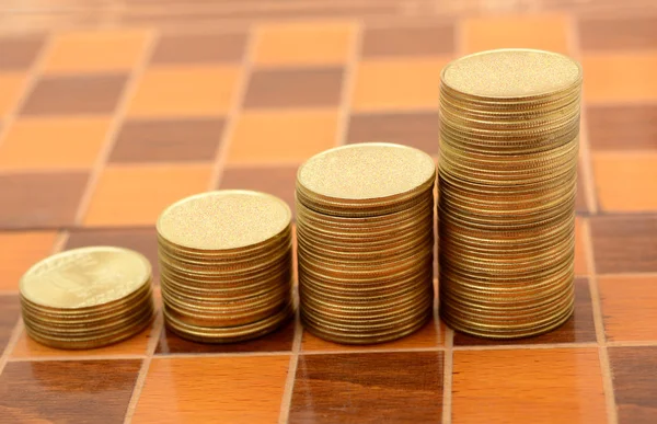 Stack of Coins making Growth graph on chess board Royalty Free Stock Images