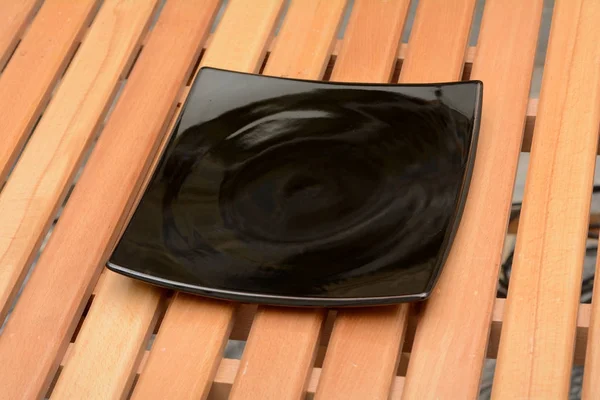 ブラック カラーのスリム プレート デザイン木製テーブルの上 — ストック写真