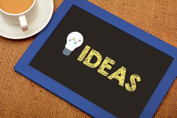 Ideias com ícone de lâmpada na ardósia quadro — Fotografia de Stock