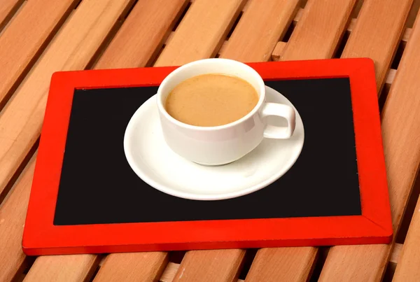 Tasse Tee auf Kreidetafel im Büro — Stockfoto