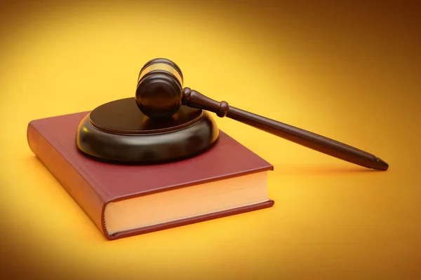 Wood Gavel on law red book yellow background