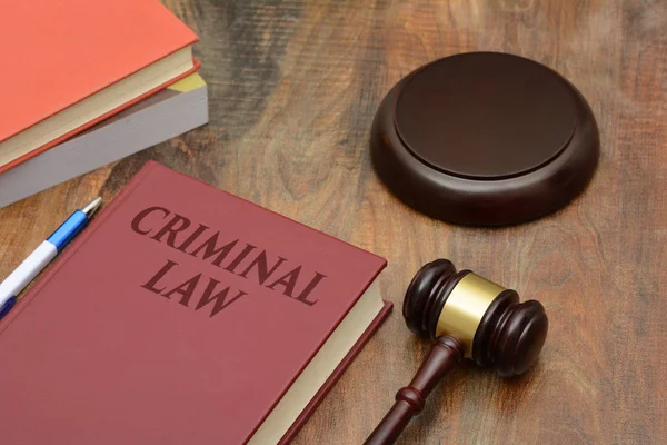 Ceza hukuku işaretiyle tahta tokmak ve kırmızı kitap