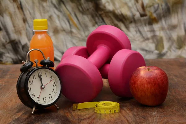 Рожеві гантелі з концепцією пристосованості до яблука та годинника — стокове фото