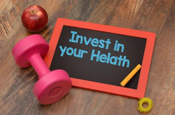 Invest in your Health concept with dumbbell and apple