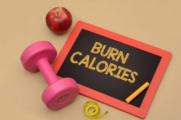 Verbranden van de calorieën bord met fitness halter en apple — Stockfoto