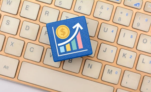 Business growth icon on wooden dice and keyboard