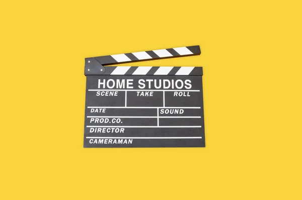 Opened movie film clap board on yellow background, film making device