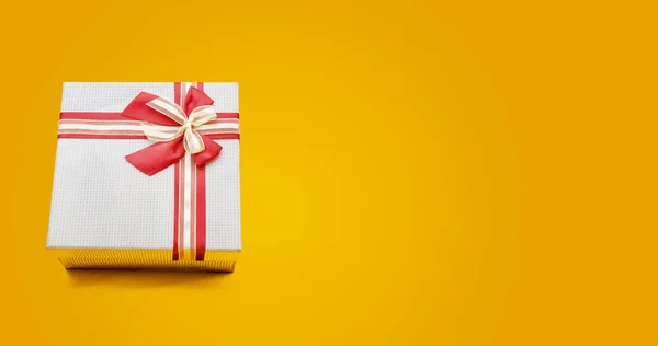Caixa de presente de Natal no banner de fundo amarelo com espaço de cópia — Fotografia de Stock