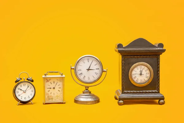 Multi type of Vintage alarm clocks isolated on yellow background with copy space — Stock Photo, Image
