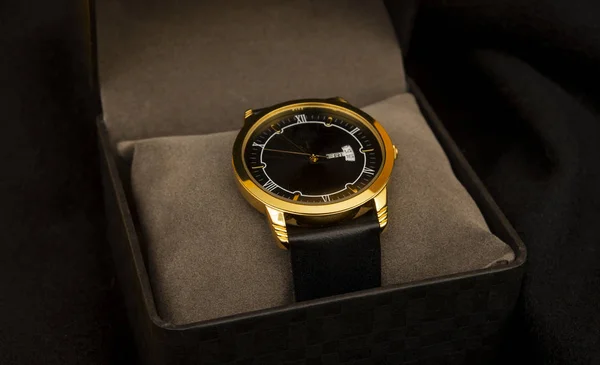 Siyah arka plandaki hediye kutusunda lüks tarzı altın kol saati. — Stok fotoğraf