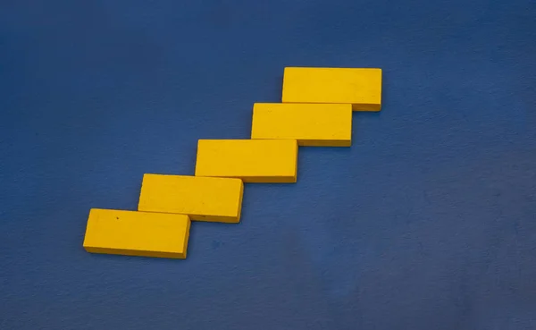 Cor amarela cubo de madeira em fundo de cor azul com conceito de sucesso de negócios — Fotografia de Stock