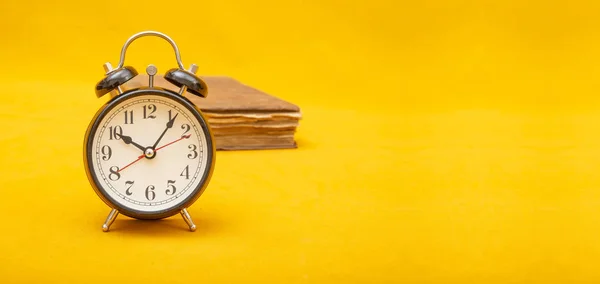 Relógio de alarme estilo vintage no banner de fundo amarelo com espaço de cópia — Fotografia de Stock