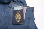 Zblízka kanadský pas a kanadský dolar na Blue Jean s kopírovacím prostorem