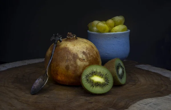 Melograno e kiwi con tavolo vintage in legno cucchiaio — Foto Stock