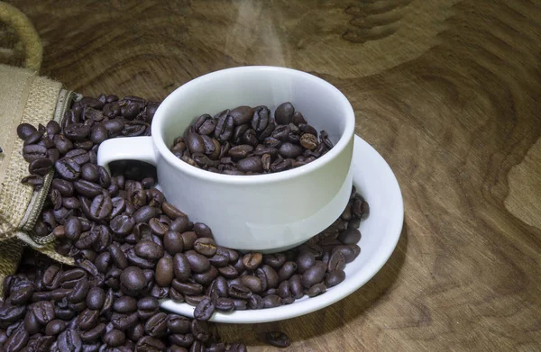 Cup full av kaffebönor på trä bakgrund med kopia utrymme — Stockfoto