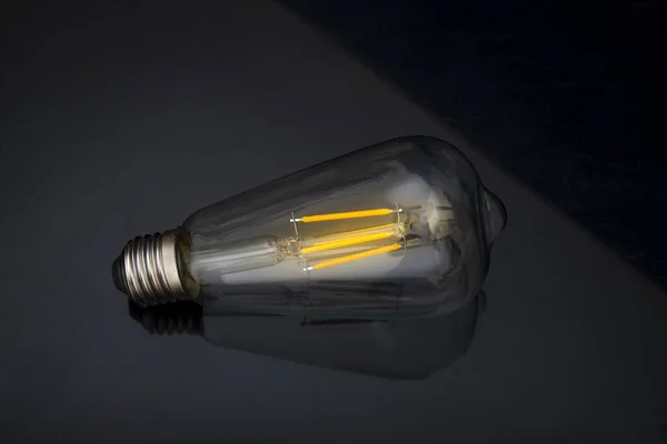 Glühbirne auf schwarzem Hintergrund, Ideenkonzept mit Kopierraum — Stockfoto