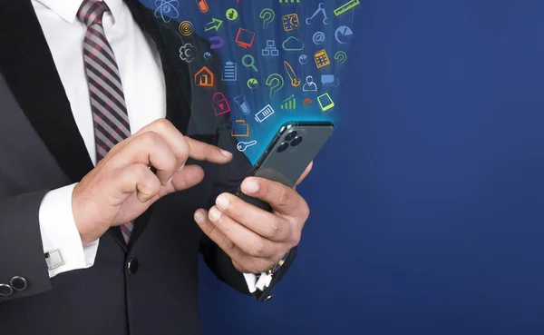 Homem profissional usando telefone celular inteligente com ícones de aplicativos flutuando ao redor — Fotografia de Stock