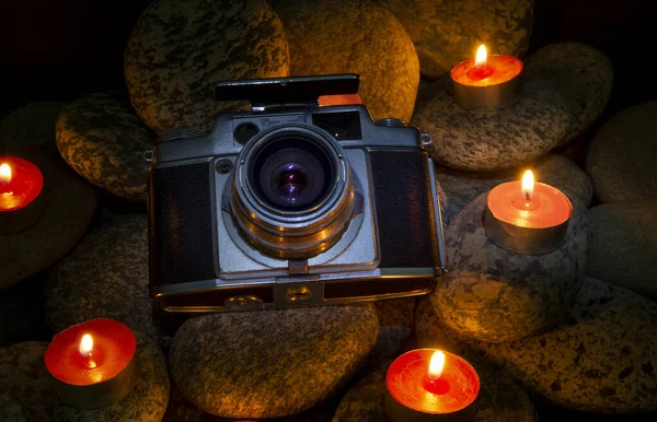 Vintage Camera zwischen brennenden Kerzen auf Steinen platziert - nostalgisches Thema — Stockfoto