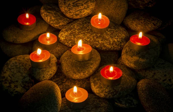 Płonące świece kompozycja na kamieniach w tle — Zdjęcie stockowe