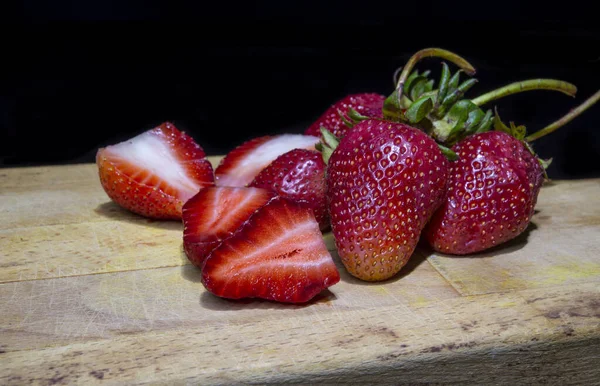 Primer plano de fresas cortar rebanadas sobre fondo de madera en la cocina — Foto de Stock