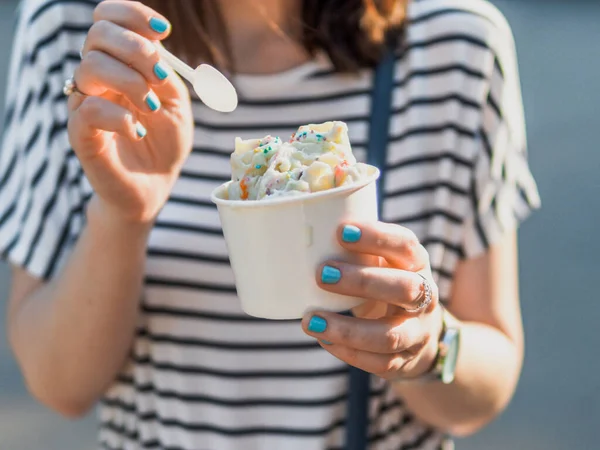 Hand holding rolled ice cream in cone cup