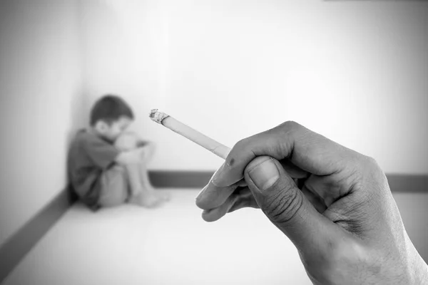 Zigarette in der Hand mit verschwommenem Bild des Jungen — Stockfoto