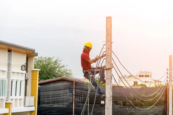 Elektrikçi elektrik direkleri tırmanma vardır — Stok fotoğraf