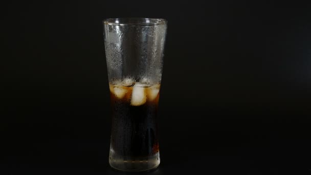 Versare la cola da una bottiglia di plastica in un bicchiere di ghiaccio — Video Stock