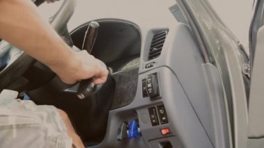 Bir adamın elini arabanın motoru, ulaşımı ve sigorta endüstrisi kavramlarını çalıştıracak anahtarla kapatın..