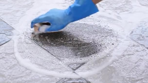戴蓝色橡胶手套的人的手被用来转换瓷砖地板上的刷洗 — 图库视频影像