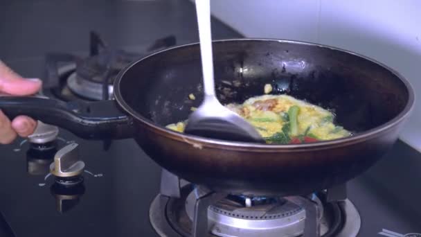 台所のガスストーブの火から熱でフライパンで卵を炒める — ストック動画