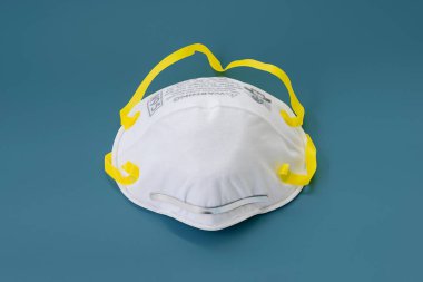 Toz, PM2.5, koku ve ürperti için N95 maskeli solunum cihazı. Coronavirus Covid-19 enfeksiyonu mavi pastel arka planda izole edildi.