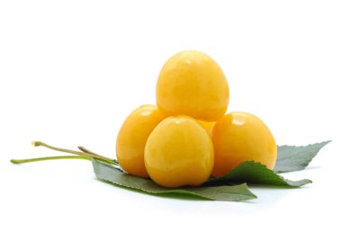 Beyaz arka planda yaprakları olan sarı kirazlar..