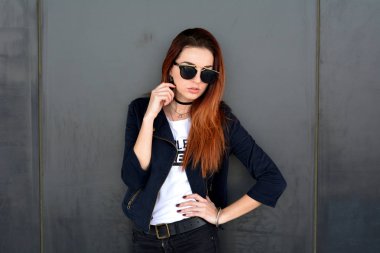 Üzgün zencefil kadın sokakta gri duvar tarafından poz. Gri arka plan.