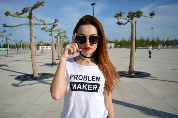 Stylish young woman looking forward and wearing sunglasses