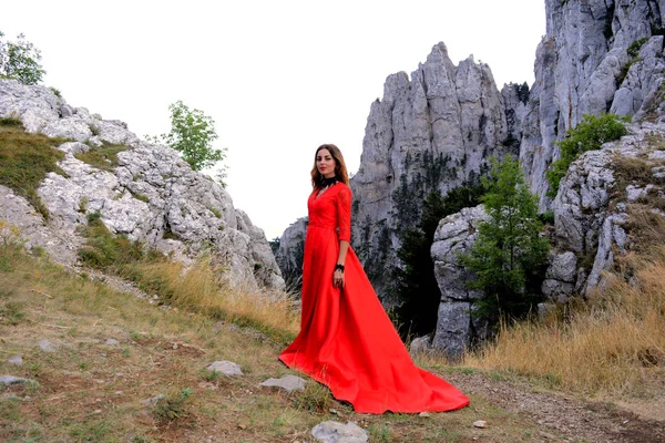 Dağlarda bir ormanda uzun Kırmızı elbiseli bir kız
