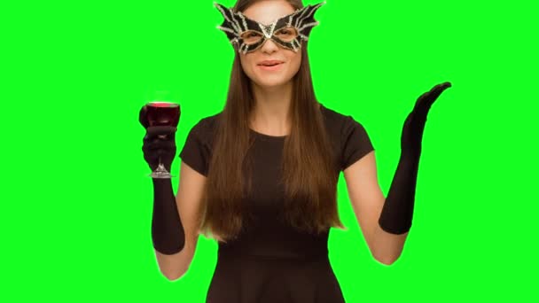 Flickan i masken och svart klänning dricka vin. och åtnjuter gott nytt år — Stockvideo