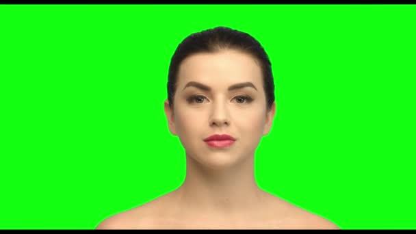 She puts on face cream, brunette on the green screen — Stock Video