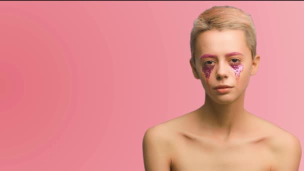 Uma menina com cabelo curto e arte de maquiagem rosa — Vídeo de Stock