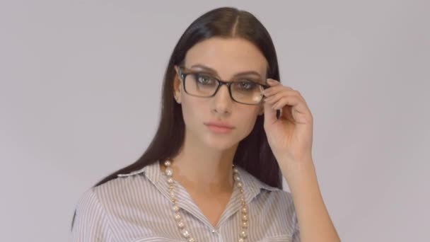 Mujer de negocios morena sonriente vistiendo camisa blanca y gafas . — Vídeos de Stock