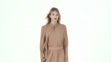 Bej elbise uçan bir modeldir. Ağır çekim