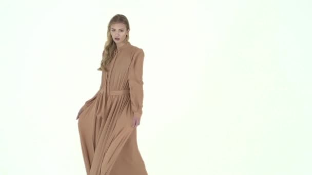 Fashion model in flying beige dress. Slow motion — Stock Video