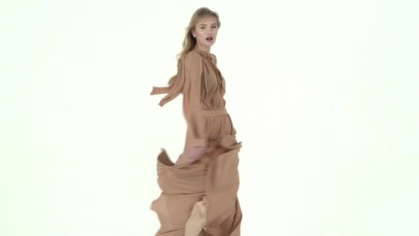 Μόδα μοντέλο στο πέταγμα μπεζ φόρεμα. Αργή κίνηση — Αρχείο Βίντεο