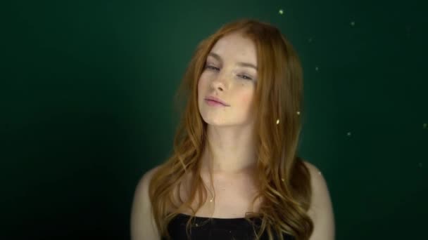 Όμορφη κοκκινομάλλα κοπέλα ποζάρει σε πράσινο φόντο. — Αρχείο Βίντεο