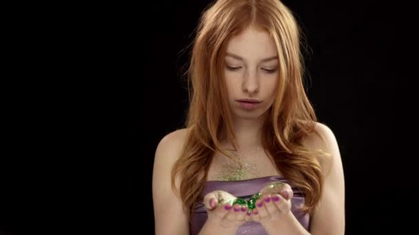 Teen κορίτσι με όμορφο πρόσωπο και κόκκινα μαλλιά φυσώντας πράσινη λάμψη — Αρχείο Βίντεο