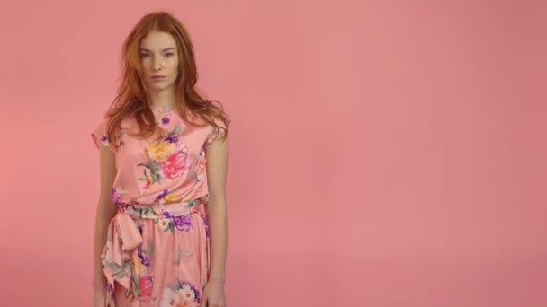 Portré vörös hajú modell rózsaszín ruha egy rózsaszín háttér