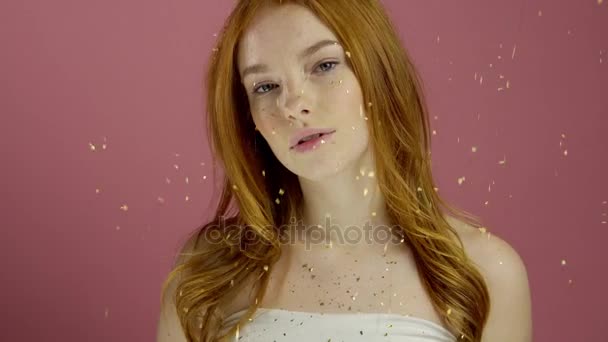 Portrait red-haired fashion model in pink dress on a pink background